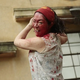 A woman swings a bloody axe at an off-screen zombie.